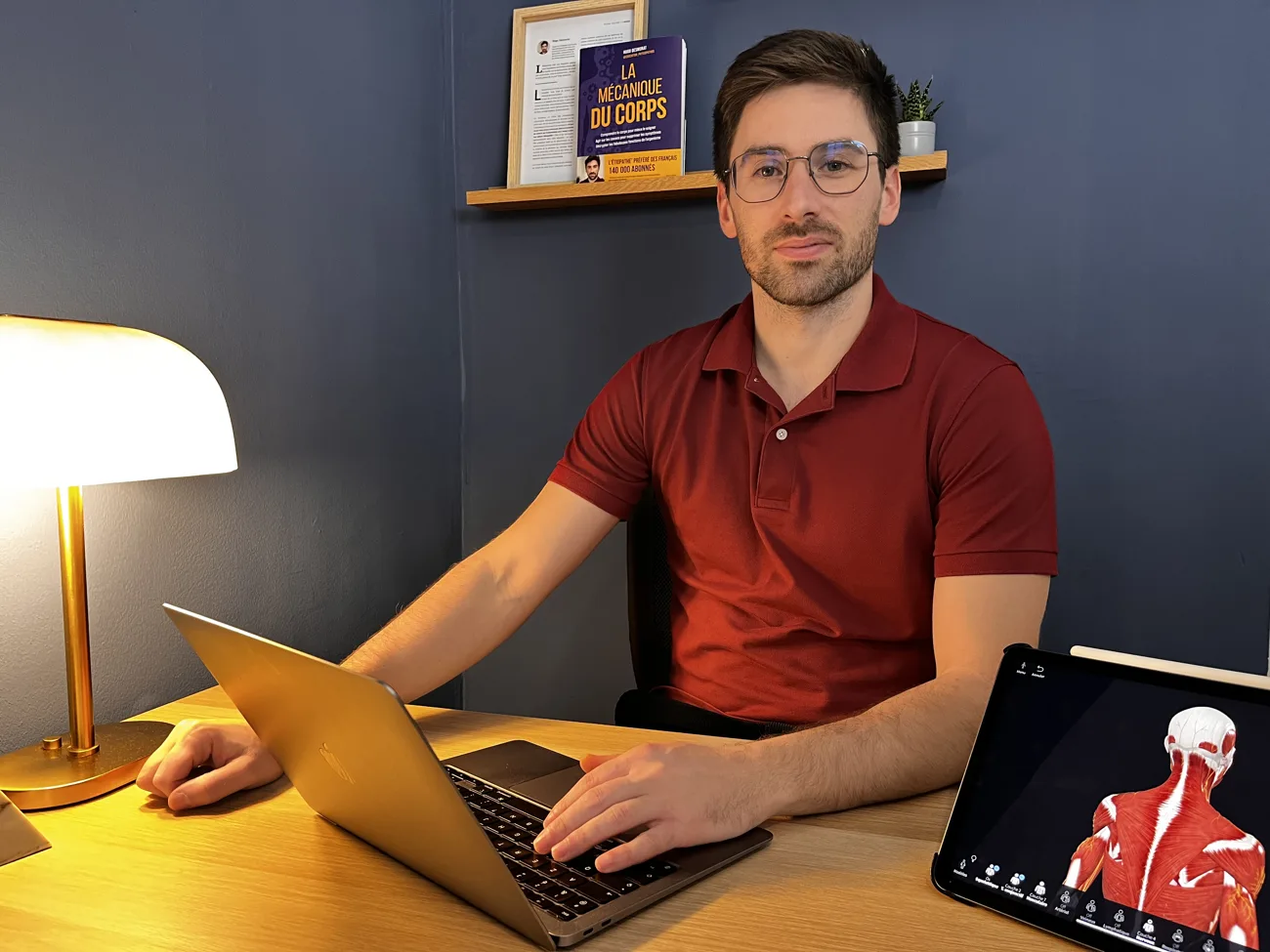 Hugo Desmorat à son bureau du cabinet, planche d'anatomie à côté